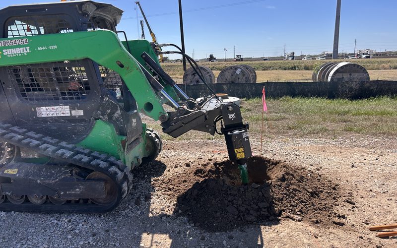 Auger drilling foundation holes at a substation site
